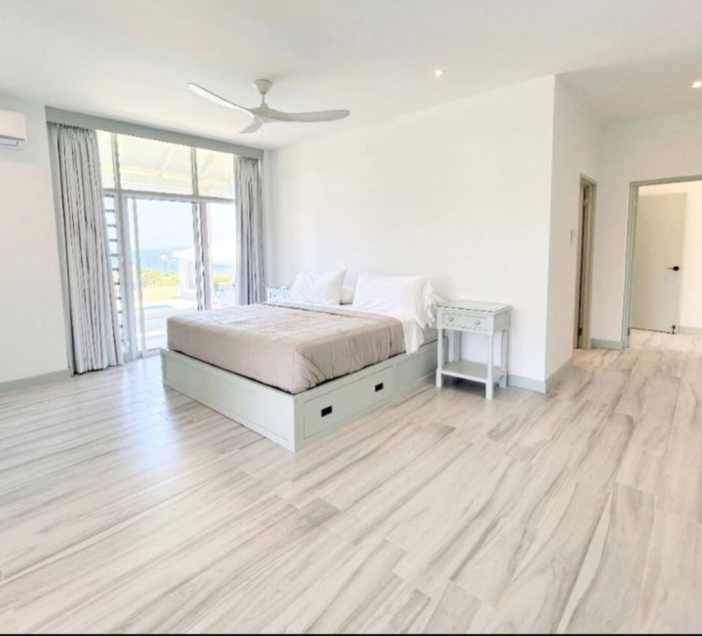 Bright Cornwall House bedroom with a king bed and a view toward the coast